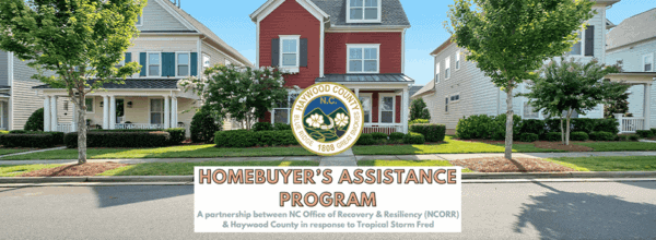 A row of suburban houses with a Haywood County seal and text: Homebuyers Assistance Program—A partnership between NCORR & Haywood County in response to Tropical Storm Fred.