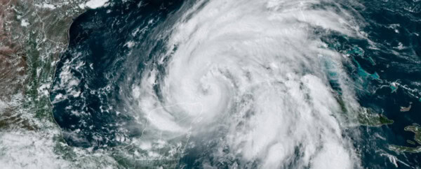 Satellite image showing a large, swirling hurricane over the Gulf of Mexico, with dense clouds covering parts of the Yucatán Peninsula, Cuba, and surrounding waters.