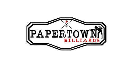 Logo for Papertown Billiards with crossed pool cues and a small P above the text, and a silhouette of a person playing pool. The word BILLIARDS is in red.