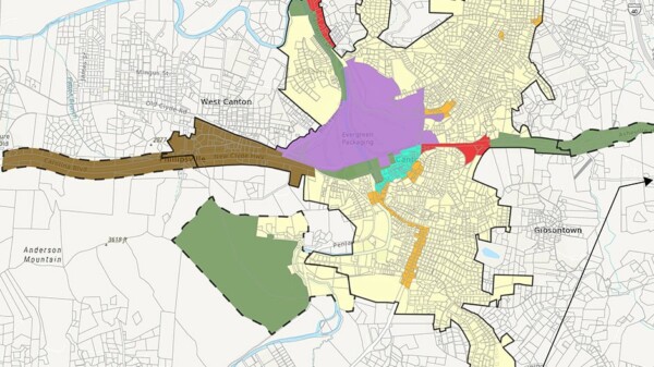 A map showing a city with different regions highlighted in colors like purple, green, orange, and brown, representing zoning or planning areas. Streets, neighborhoods, and borders are detailed in black lines.