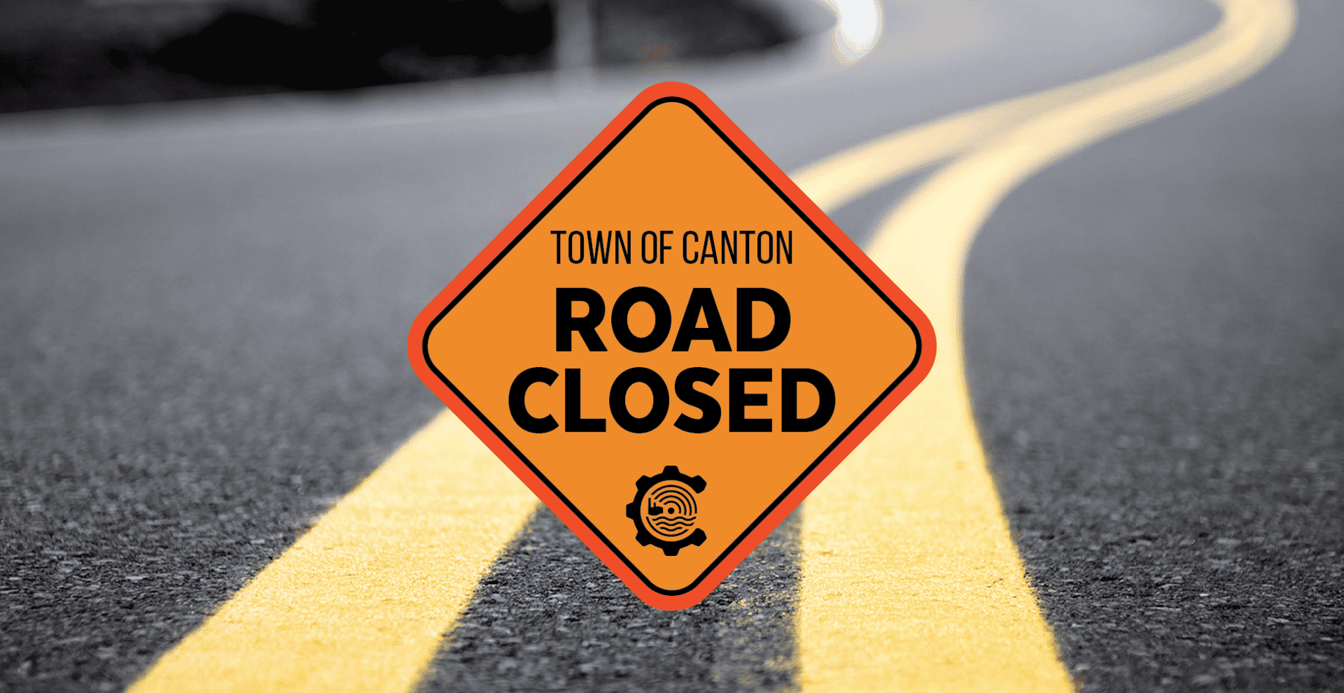 Orange diamond Road Closed sign with Town of Canton text is centered on a road with double yellow lines. The road curves and fades into the background.