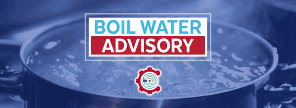 A large pot of boiling water with a sign that reads Boil Water Advisory in bold letters, and a water-related logo underneath.