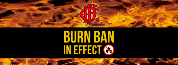Burn Ban in Effect text with a fire department logo above, flames in the background, and a no fire symbol.